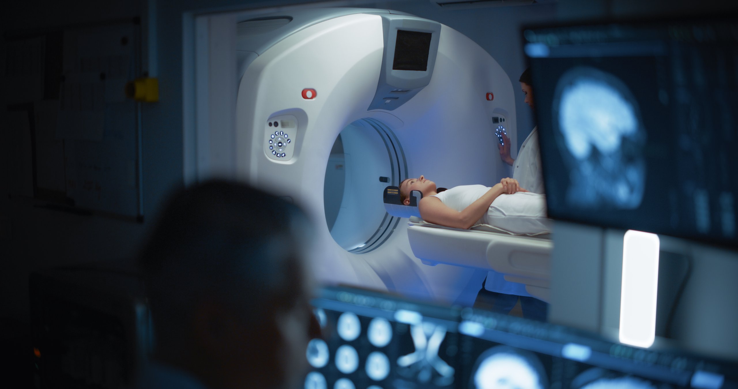 Paciente en MRI cerebral, neurólogo monitoreando resultados en sala de control