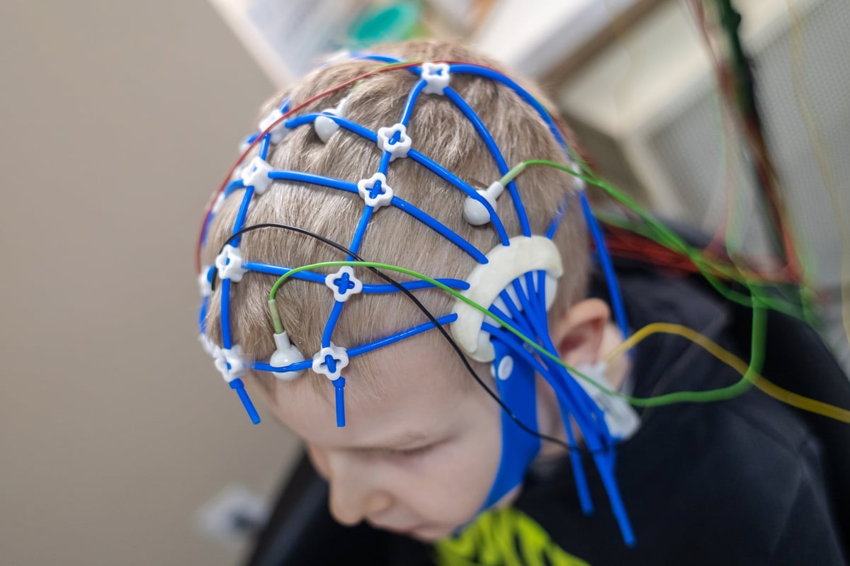 A boy's brain is examined on an EEG machine in a hospital laboratory