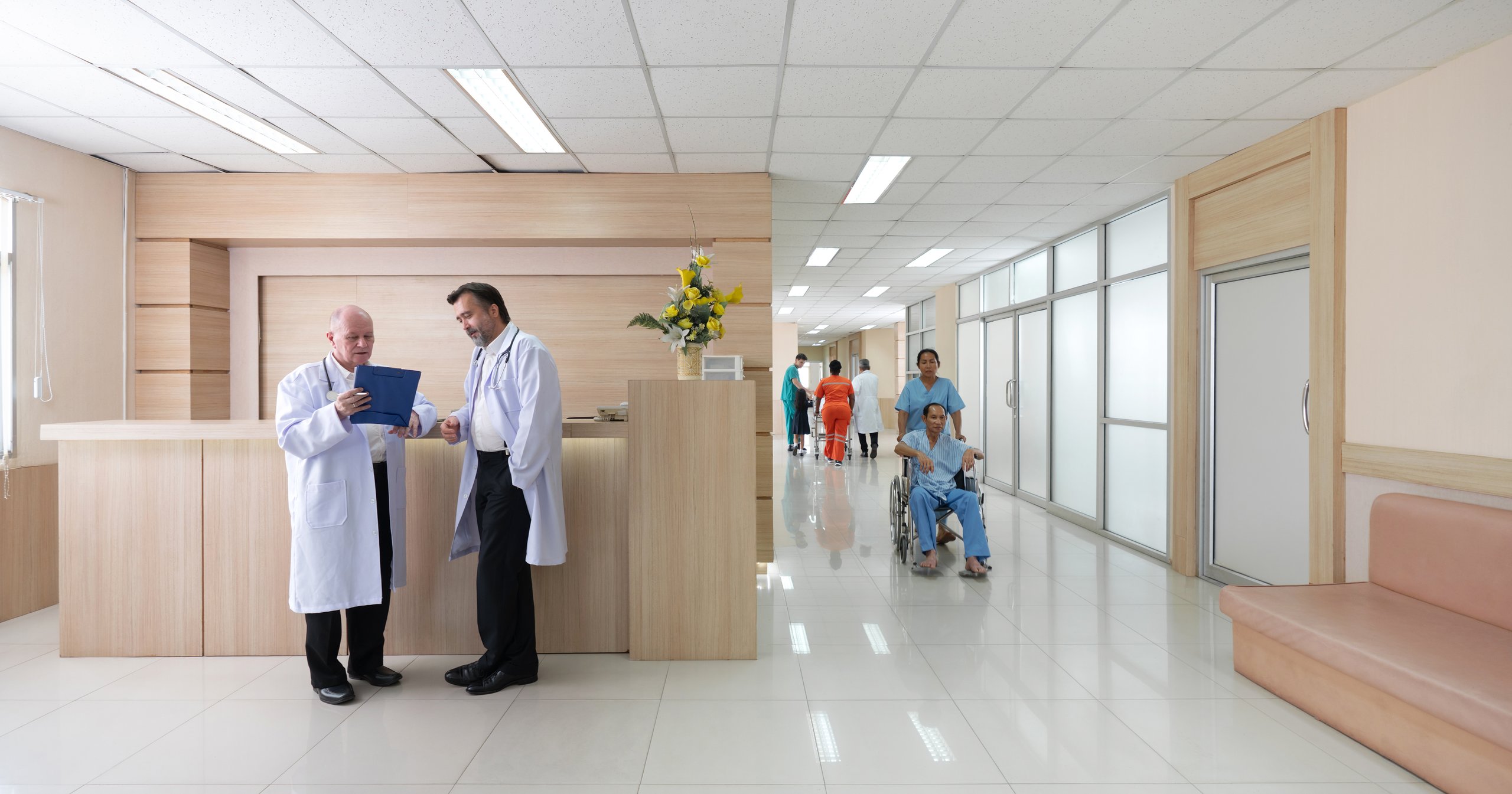 Médicos revisando documentos en área de recepción de hospital contemporáneo