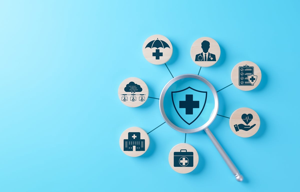 Health Insurance and Medical Care Concept: magnifying glass on shield with medical cross representing health insurance coverage
