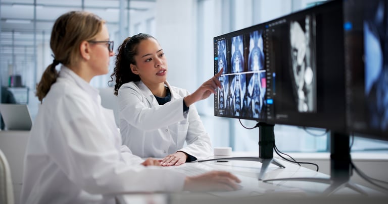 Médica radióloga examinando resonancia magnética de columna en computadora