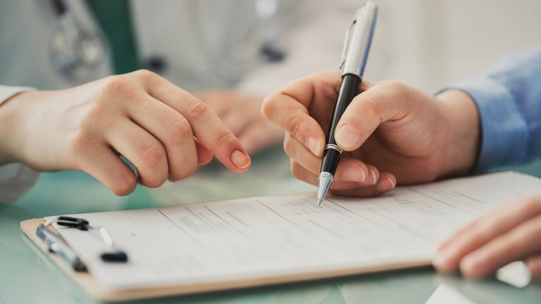 Doctor asistiendo a paciente con formulario médico