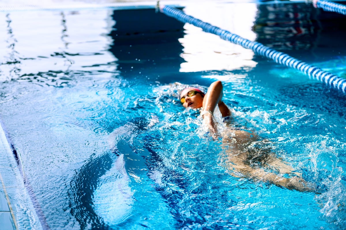 Female athlete actively swimming in a pool, demonstrating skill and dedication in water sports