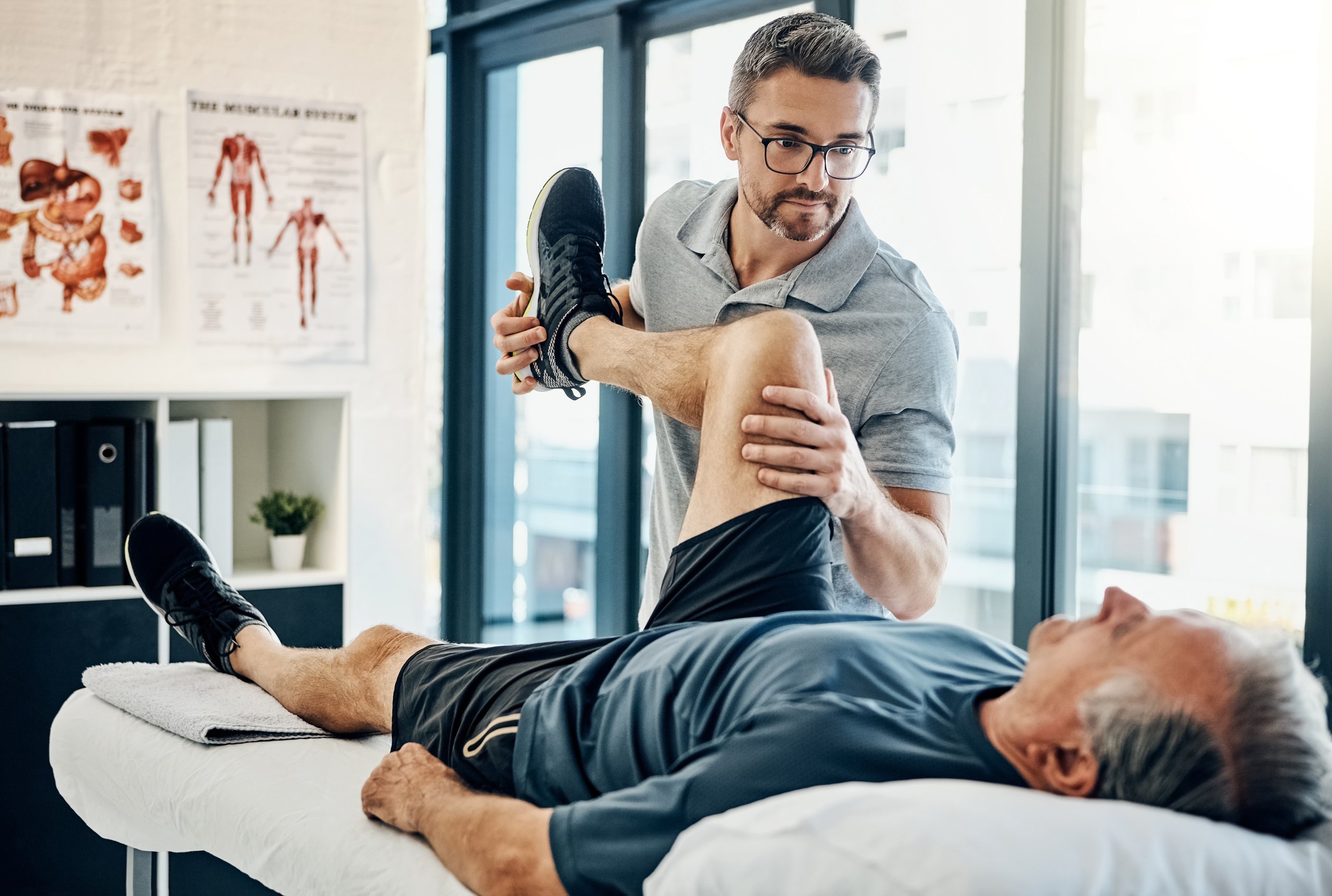 Fisioterapeuta amable tratando a paciente en centro de rehabilitación moderna